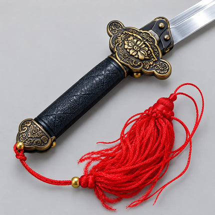 Close-up of ornate gold-tone guard, dark handle and red tassel