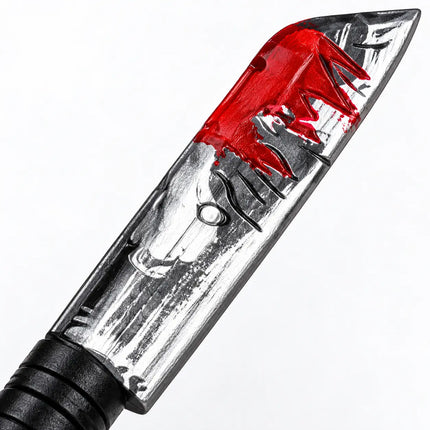 Close-up of silver-tone blade with red and dark decorative patterns
