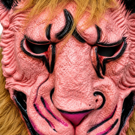 Close-up of pink monster mask textured face and black eye accents