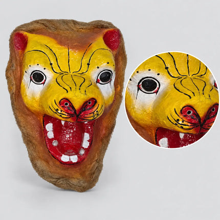 Close-up of yellow painted mask face and red mouth details